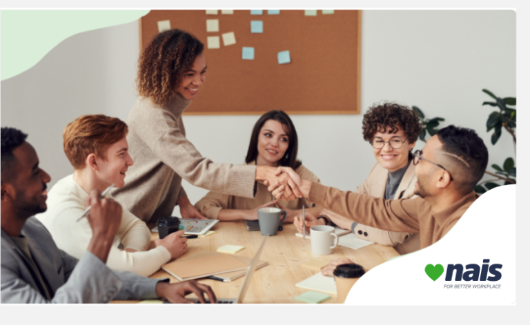 Group of people working a table smiling and shaking hans with green frame and company logo