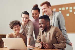 Grouo of coworkers smiling at a laptop screen